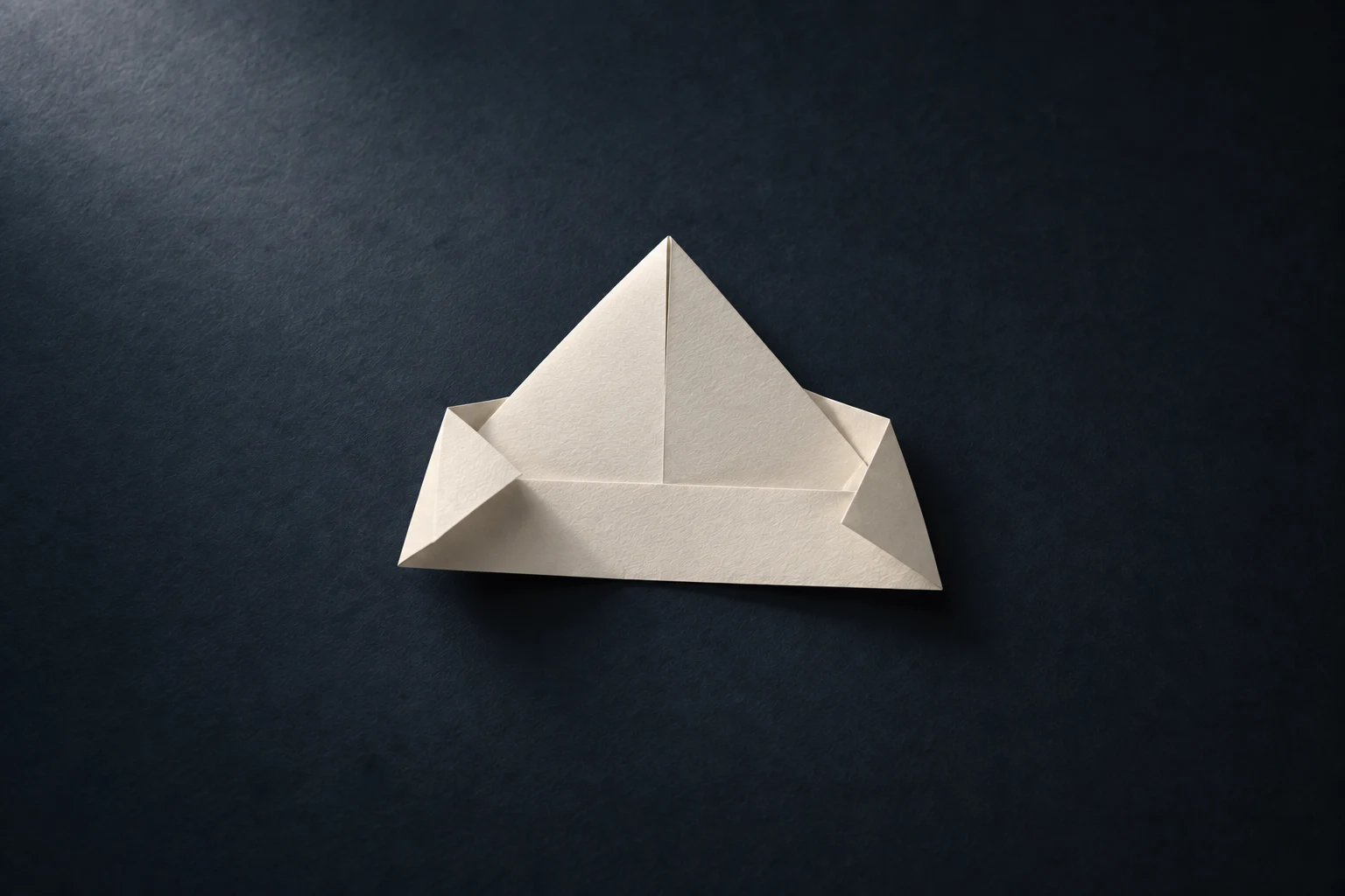 La même feuille blanche, davantage pliée et presque devenue un chapeau de papier