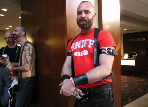 Attendees socialize in the Hyatt Regency lobby during Mid-Atlantic Leather Weekend in 2014; a man in the foreground wears a leather vest and accessories.