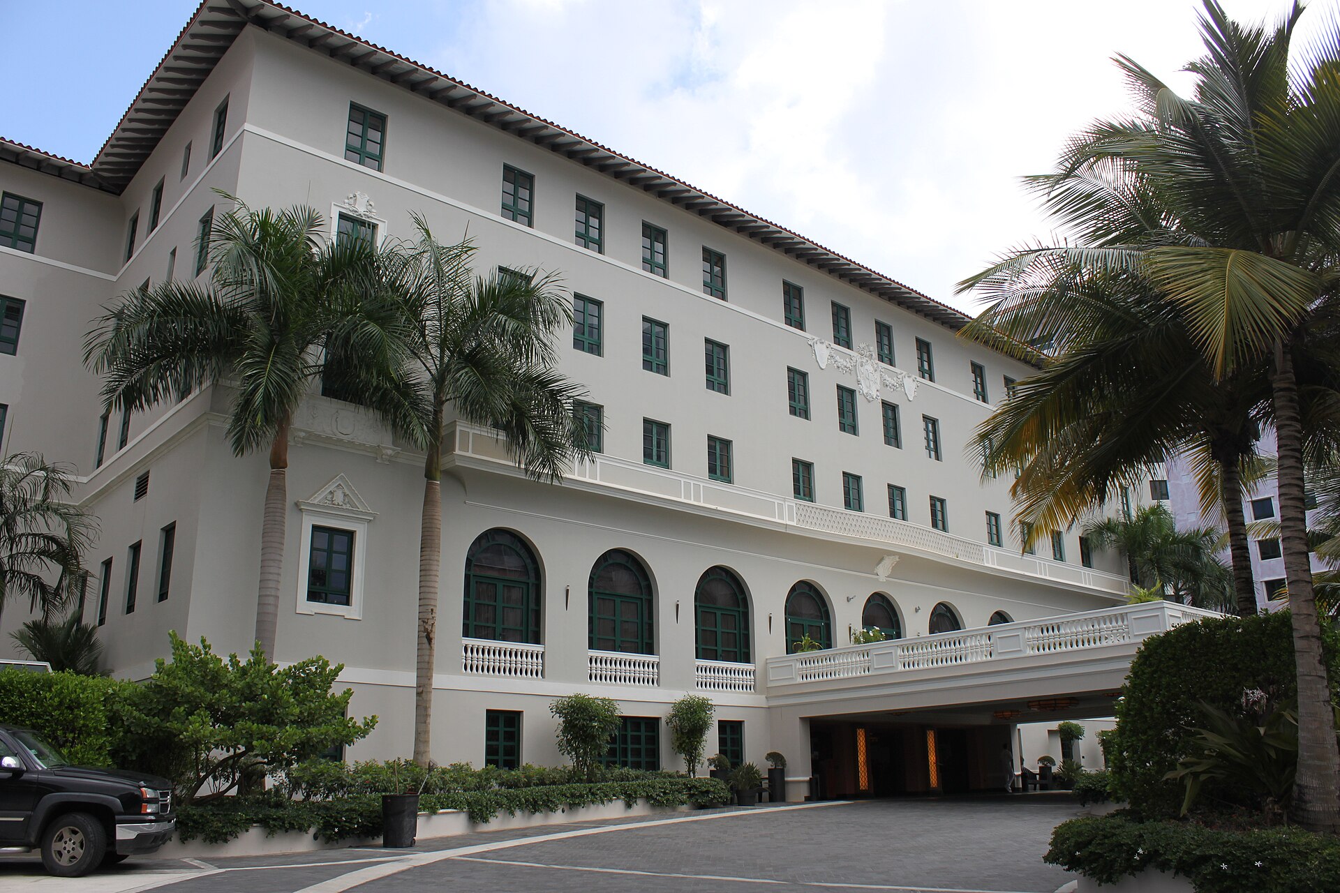 The historic facade of the Condado Vanderbilt Hotel framed by palms.
