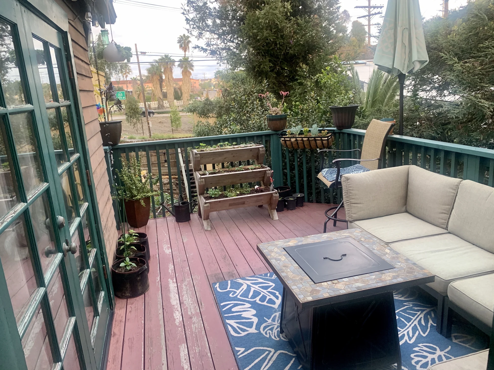 A green glass door opening from a bedroom onto a planted deck in Hillcrest, San Diego.